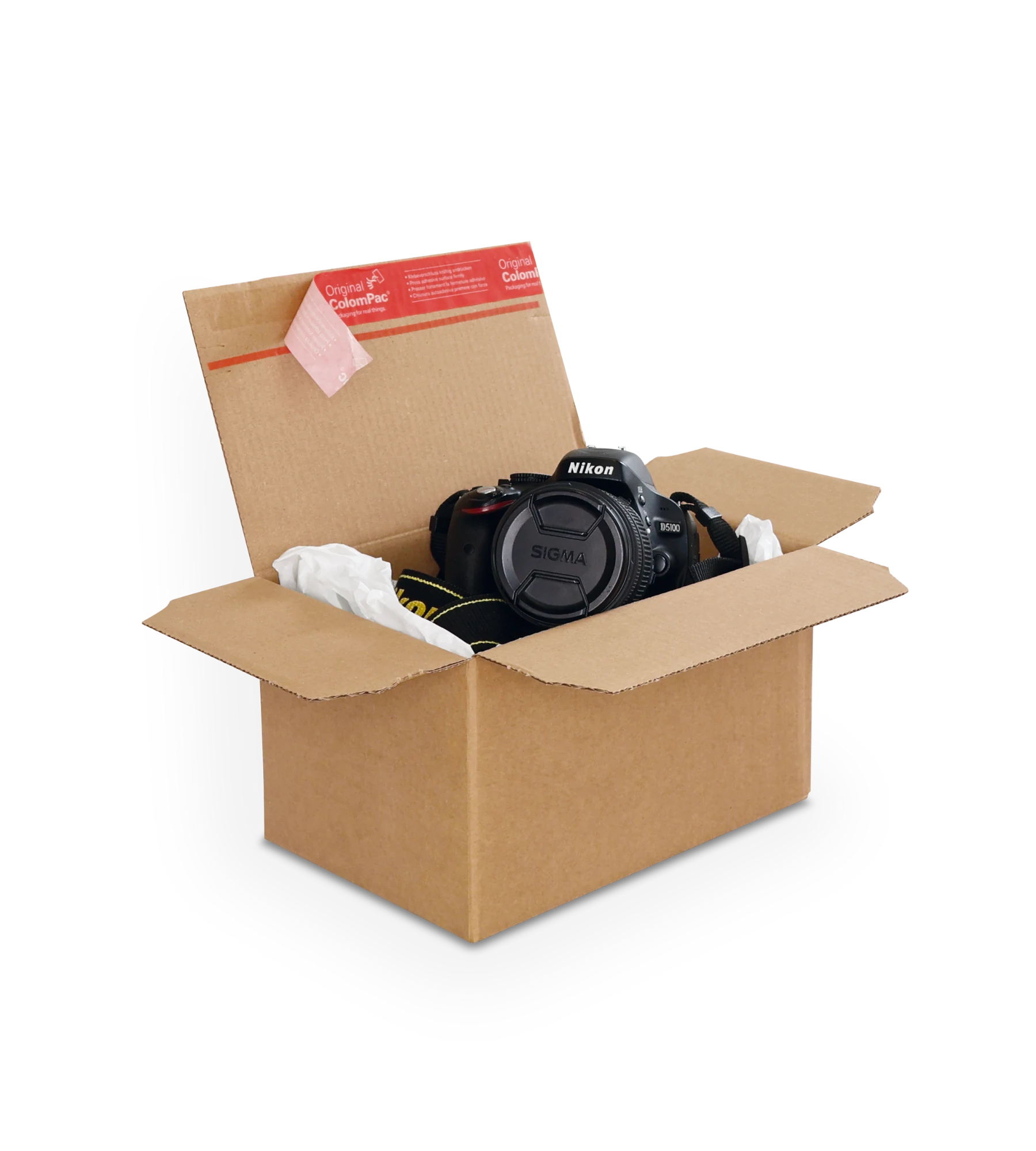 Geöffneter brauner Versandkarton aus Wellpappe mit einer Nikon-Kamera samt angebrachtem  Objektiv, eingebettet in Verpackungsmaterial. Auf der oberen Klappe ein roter ColomPac-Selbstklebeverschluss.