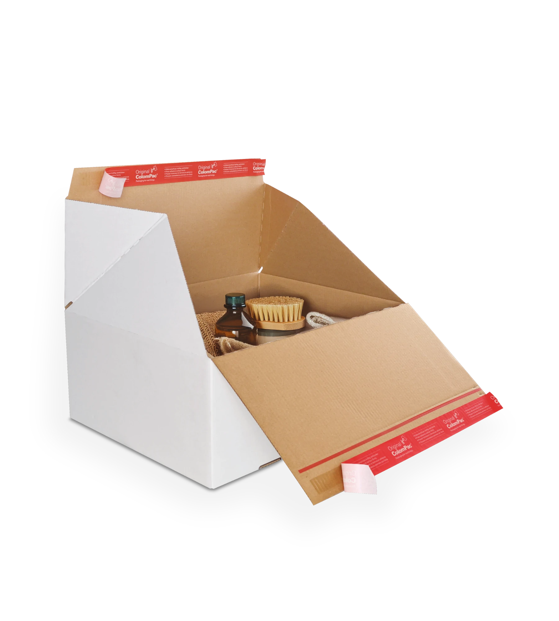 Geöffneter Versandkarton aus Wellpappe mit weißer Außenseite und brauner Innenseite enthält mehrere Gegenstände, darunter eine kleine Flasche mit dunklem Deckel und eine Bürste mit Borsten. Mit ColomPac-Selbstklebeverschluss an den Deckelklappen.